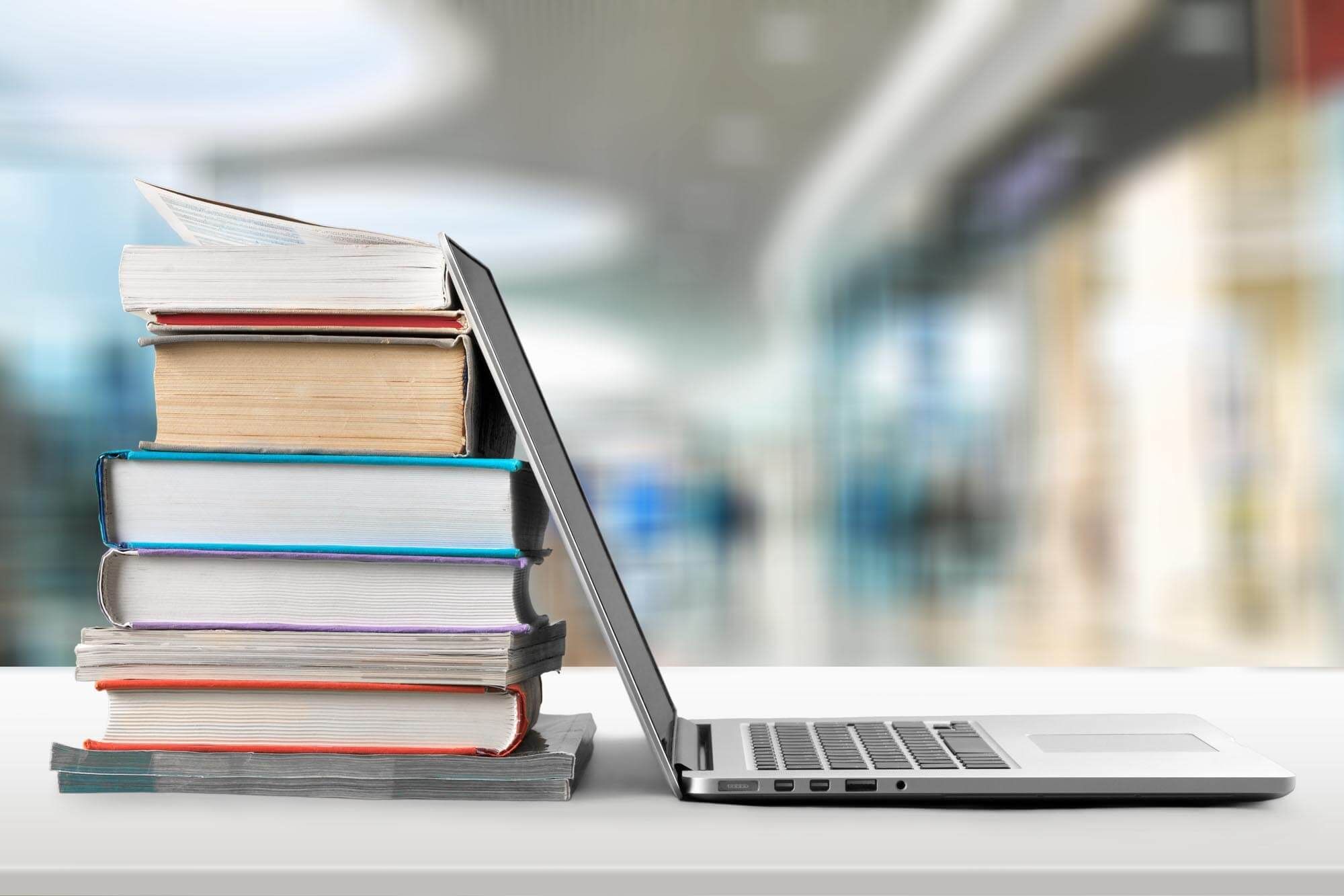 Stack of books next to laptop